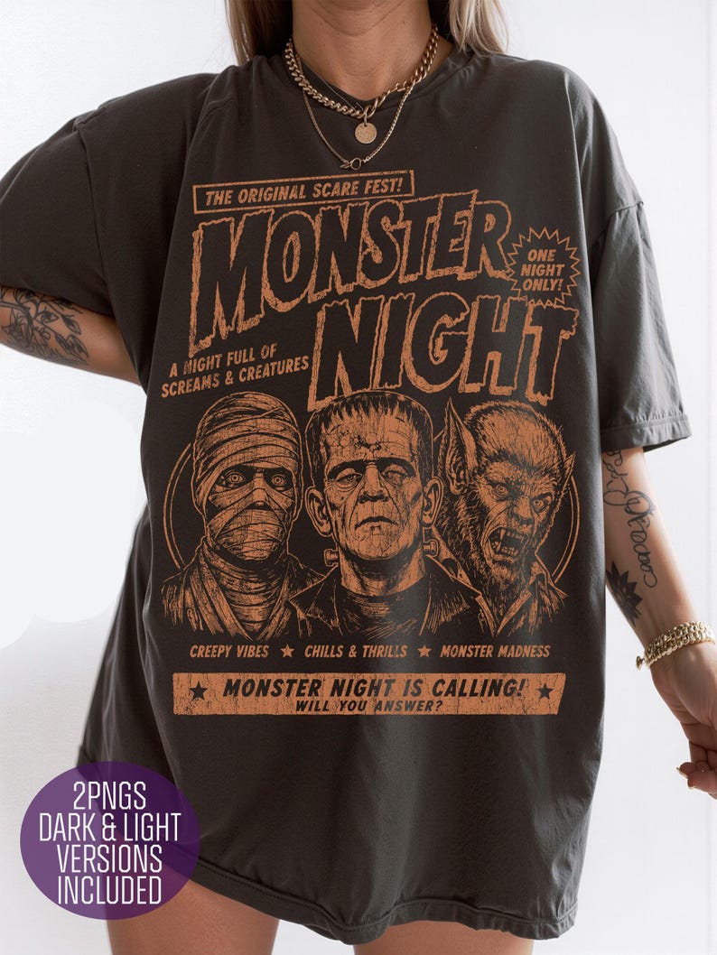May include: A charcoal gray t-shirt featuring an orange graphic print with the text "MONSTER NIGHT," "THE ORIGINAL SCARE FEST!," "ONE NIGHT ONLY!," "A NIGHT FULL OF SCREAMS & CREATURES," "CREEPY VIBES," "CHILLS & THRILLS," "MONSTER MADNESS," and "MONSTER NIGHT IS CALLING! WILL YOU ANSWER?" depicting a mummy, Frankenstein's monster, and a werewolf.