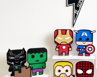 May include: A collection of colorful superhero figurines, including Iron Man, Captain America, and Spider-Man, displayed on a white shelf. The figures have a blocky, cartoonish design. A black lightning bolt with the text "BE SUPER" is also present.