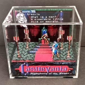 Könnte beinhalten: Ein 3D-Diorama von Castlevania: Symphony of the Night in einer durchsichtigen Acrylbox. Die Szene zeigt einen verpixelten Thronsaal mit Dracula und Richter sowie den Text: What is a man? A miserable little pile of secrets.