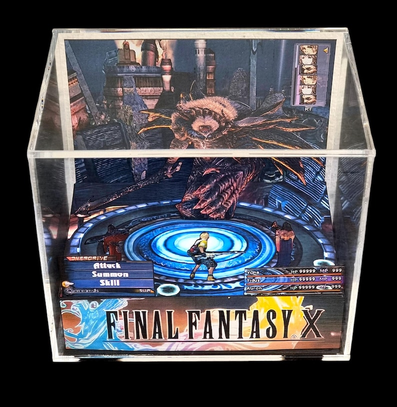 May include: A Final Fantasy X diorama encased in a clear acrylic box. The scene depicts a battle with characters and a monster, with game interface details visible. The game's logo is at the bottom.