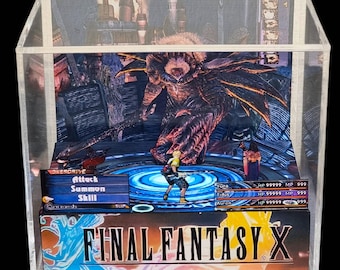 May include: A Final Fantasy X diorama in a clear acrylic display case. The scene depicts a battle with characters and a monster. The game's title is displayed at the bottom. The diorama is a collectible item.