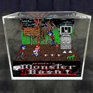 May include: A 3D diorama of the video game Apogee's Monster Bash enclosed in a clear acrylic display case. The scene features pixelated characters, a wooden sign reading DO NOT FEED THE ZOMBIES, a tombstone with R.I.P. 1801-1923, and game title text.