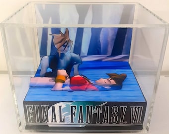 May include: A clear acrylic cube display case containing a 3D diorama of a scene from Final Fantasy VII. The diorama features two figures, one standing and one lying down, set against a blue background with the text FINAL FANTASY VII on the front.