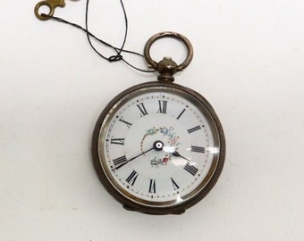 Reloj de bolsillo de plata antigua con llave de cuerda.