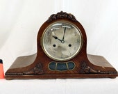 Antique oak mantel clock with ornaments.