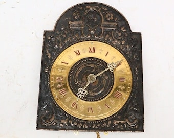 Antique wall clock with bronze front and wooden clock case