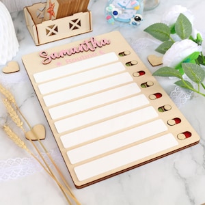 May include: A wooden personalised chore chart with the name Samantha and the word Routine. The chart has eight blank spaces for writing tasks and a row of colourful circles to mark completion.