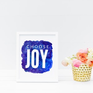Puede incluir: Impresi&oacute;n enmarcada en blanco con un fondo de acuarela azul y morado con estrellas blancas. El texto "CHOOSE JOY" est&aacute; en letras blancas en la impresi&oacute;n.