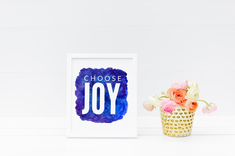 Puede incluir: Impresi&oacute;n enmarcada en blanco con un fondo de acuarela azul y morado con estrellas blancas. El texto "CHOOSE JOY" est&aacute; en letras blancas en la impresi&oacute;n.