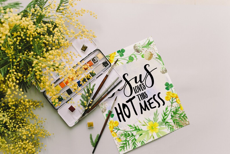 Puede incluir: Una pintura de acuarela con un dise&ntilde;o floral y el texto "Jesus loves this hot mess". La pintura est&aacute; rodeada de una paleta de acuarela, pinceles y una rama de mimosa amarilla.