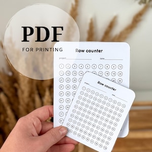 以下が含まれることがあります： 黒い文字が入った2枚の白い段数カウンターカード。カードには、編み物やかぎ針編みのプロジェクトで段を追跡するための、番号付きの円のグリッドがあります。「PDF FOR PRINTING」というテキストが上部にあります。