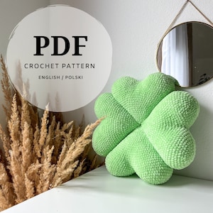 May include: PDF crochet pattern for a green four-leaf clover pillow. The pattern is available in English and Polish.