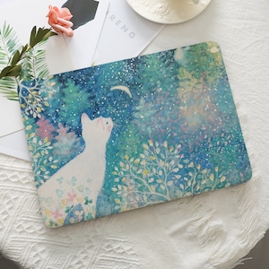 May include: A white cat looking up at a crescent moon in a blue and green watercolor painting. The cat is surrounded by small white flowers and green leaves. The background is a dark blue sky with white stars and a crescent moon.
