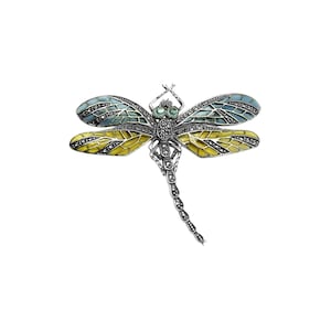 May include: A silver dragonfly brooch with green and blue enamel wings and a yellow body. The wings are decorated with marcasite stones.