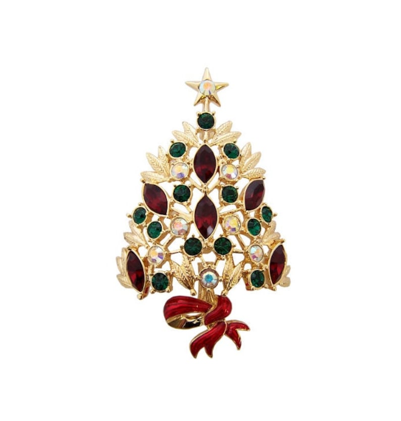 May include: Gold-coloured Christmas tree brooch with red, green, and iridescent gemstones. The brooch has a star at the top and a red bow at the base. A festive accessory for the holiday season.