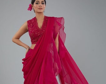 A red organza ruffled saree paired with a red handwork designer blouse is a bold and stylish choice, perfect for special occasions.