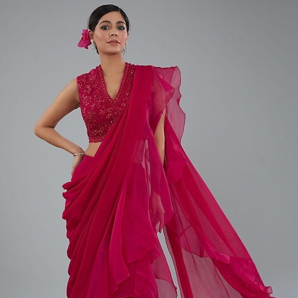 A red organza ruffled saree paired with a red handwork designer blouse is a bold and stylish choice, perfect for special occasions.