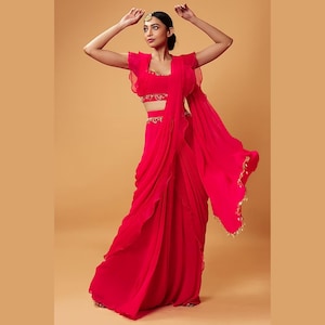 Designer Pink Organza Ruffle Saree with lace work is paired with a matching blouse wear on a wedding or any occasion, and it looks gorgeous.