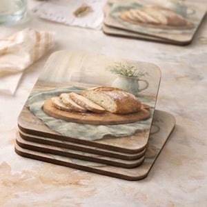 May include: Set of four square coasters featuring a rustic bread loaf on a wooden cutting board. The image has a soft, vintage aesthetic with a light blue linen cloth and a small white pitcher with greenery.