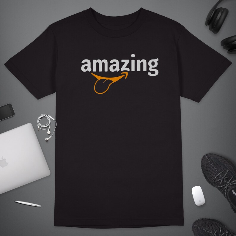 Peut inclure: T-shirt noir avec le mot "amazing" imprim&eacute; en blanc avec un smiley orange stylis&eacute;.