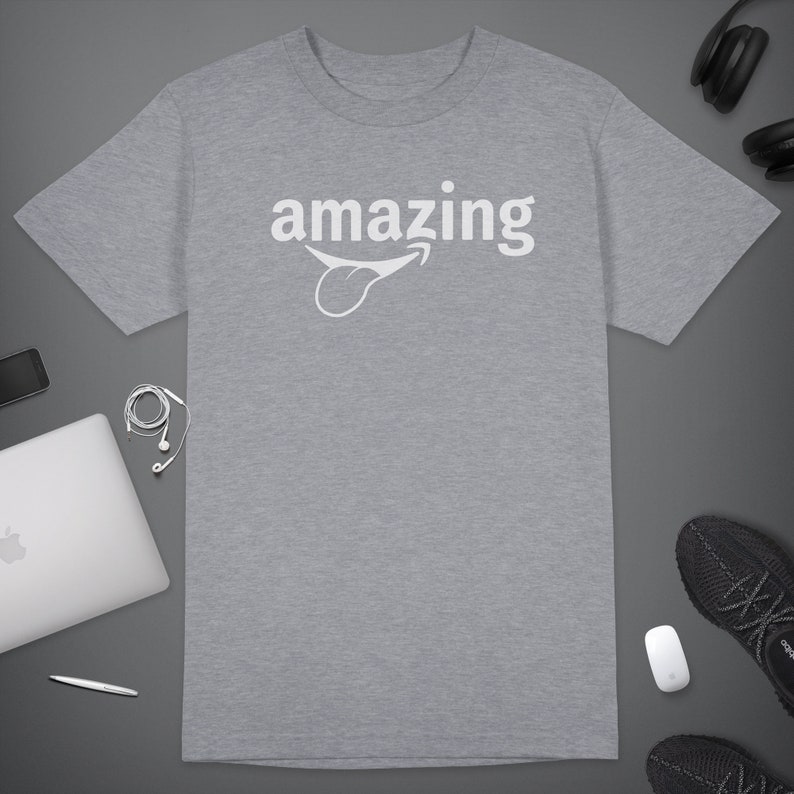 Peut inclure: Un t-shirt gris chin&eacute; avec le mot "amazing" imprim&eacute; en blanc avec une langue de dessin anim&eacute; qui sort.