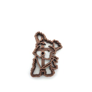 May include: A brown 3D printed cookie cutter shaped like a koala bear.