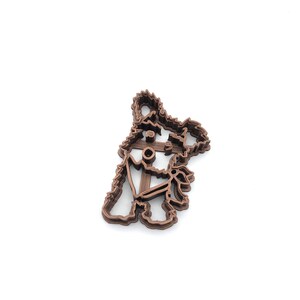 May include: A brown 3D printed cookie cutter shaped like a dog with an anchor on its chest.