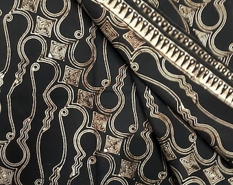 Könnte beinhalten: Schwarzer Stoff mit einem weißen und braunen geometrischen Muster. Das Muster zeigt sich in sich wiederholenden geschwungenen Linien und Quadraten.