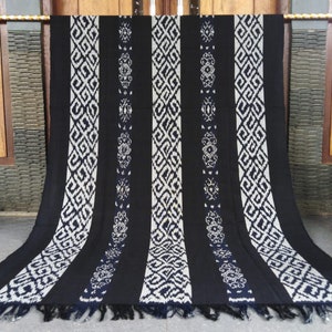 May include: Black and white woven throw blanket with a geometric pattern. The blanket has a fringe border.