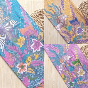 Pode incluir: Três peças de tecido retangulares com padrões de batik intrincados apresentando pássaros estilizados e motivos florais. Os têxteis exibem paletas de cores vibrantes em azul, rosa, amarelo e roxo, com designs botânicos detalhados.