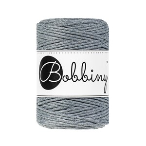 May include: A roll of gray cotton cord with a white label that says "Bobbiny" in black cursive lettering.