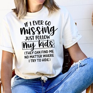 以下が含まれることがあります： 白いTシャツに黒い文字で「もし私が行方不明になったら、私の子供たちについていけばいい（彼らは私がどこにいようとも見つけることができる）」と書かれている