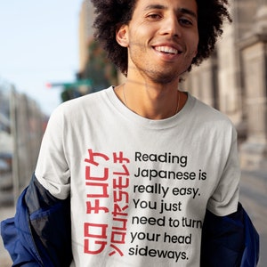 May include: A white t-shirt with a red Japanese phrase that reads "GO FUCケソロリヤSモレチ" and the text "Reading Japanese is really easy. You just need to turn your head sideways."