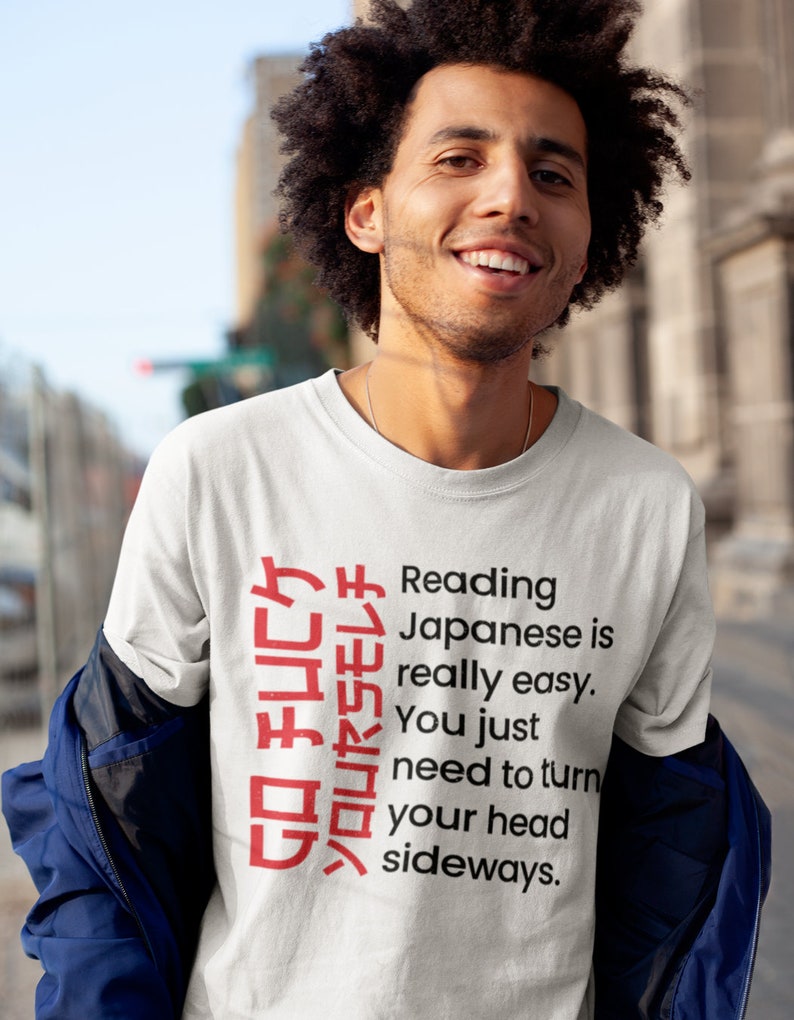 May include: A white t-shirt with a red Japanese phrase that reads "GO FUCケソロリヤSモレチ" and the text "Reading Japanese is really easy. You just need to turn your head sideways."