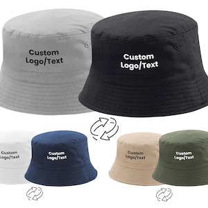May include: Six different coloured bucket hats with the text "Custom Logo/Text" embroidered on the front. The hats are in the colours white, navy blue, beige, green, grey, and black.