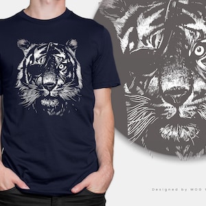 Puede incluir: Una camiseta azul marino con un gráfico blanco de un tigre con un parche en el ojo. La cara del tigre está de cerca y la imagen es de estilo vintage. El texto "Designed by MOG Print" está en la parte inferior de la imagen.