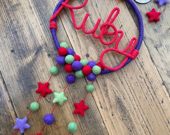 Purple and red name hoop with hanging stars and pompoms