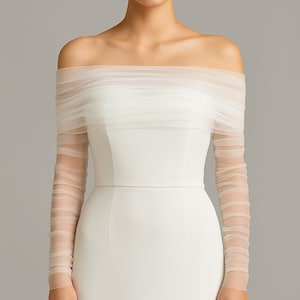 May include: White off-the-shoulder wedding dress with sheer, ruched sleeves. The fitted bodice and delicate, semi-transparent sleeves create an elegant silhouette. A simple design, suitable for a wedding or special event.