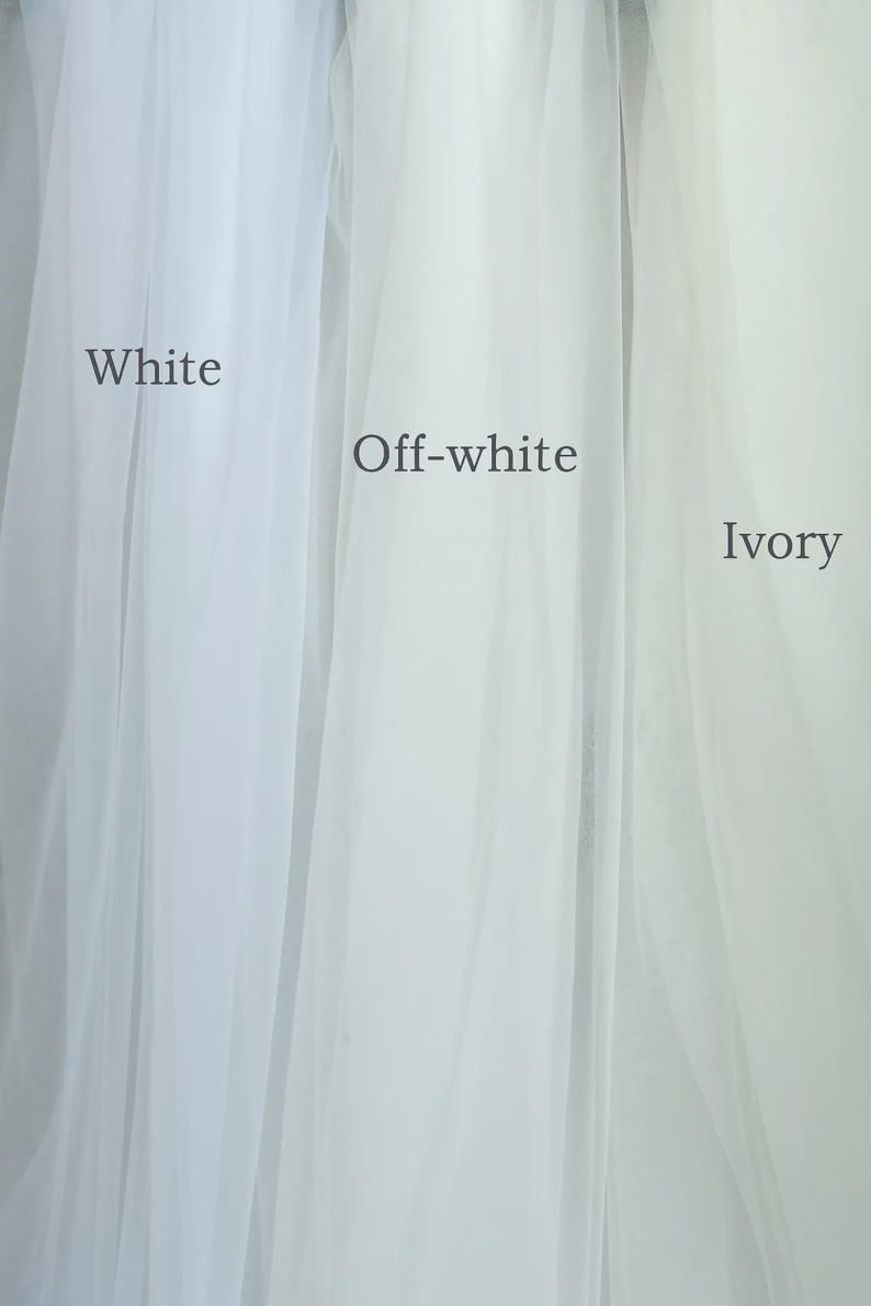 May include: A vertical image showcasing three fabric swatches in varying shades of white: white, off-white, and ivory. The names of the colors are printed on the fabric. The sheer material is likely tulle or a similar lightweight fabric.