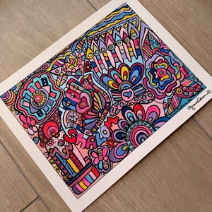 May include: A colorful art print featuring a hamsa hand, a menorah, and floral patterns in shades of pink, blue, yellow, and purple. The word Shalom is written in stylized pink letters. The artist's signature, Grace Cohen, appears in the corner.
