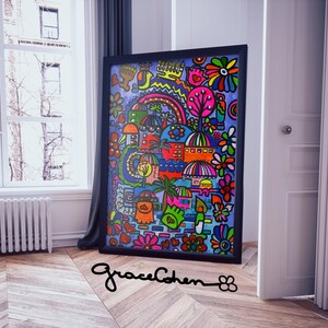 Puede incluir: Una obra de arte abstracta colorida enmarcada en un marco negro. La obra presenta una vibrante mezcla de formas, incluyendo flores, edificios y un arco&iacute;ris, en tonos de rojo, azul, verde y amarillo. La firma del artista, "graceCohen", es visible.