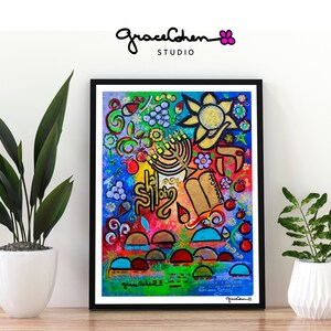 Puede incluir: Impresi&oacute;n art&iacute;stica abstracta y colorida enmarcada en negro. La obra presenta una vibrante mezcla de colores y formas, incluyendo una menor&aacute;, un sol y texto hebreo. La firma del artista es visible. La impresi&oacute;n se exhibe sobre una superficie de madera.