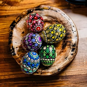 May include: Six painted eggs in a wooden bowl. The eggs are decorated with colorful dots and patterns in shades of pink, yellow, green, blue, and purple.