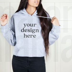 May include: A gray hooded sweatshirt with the text "your design here" printed on the front.