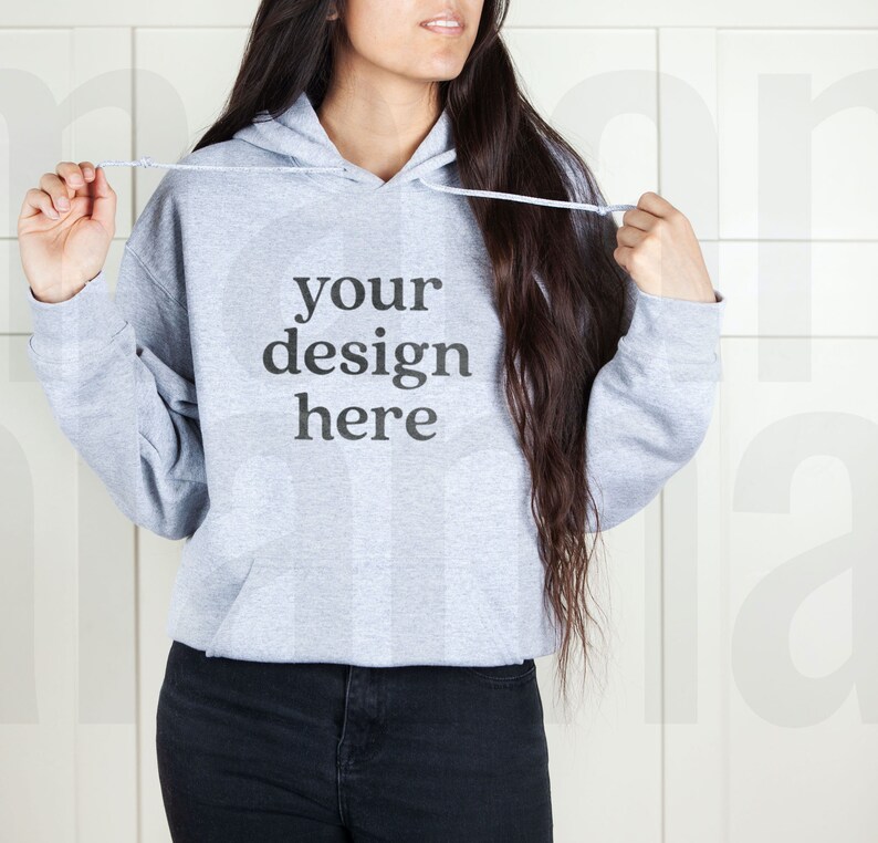May include: A gray hooded sweatshirt with the text "your design here" printed on the front.