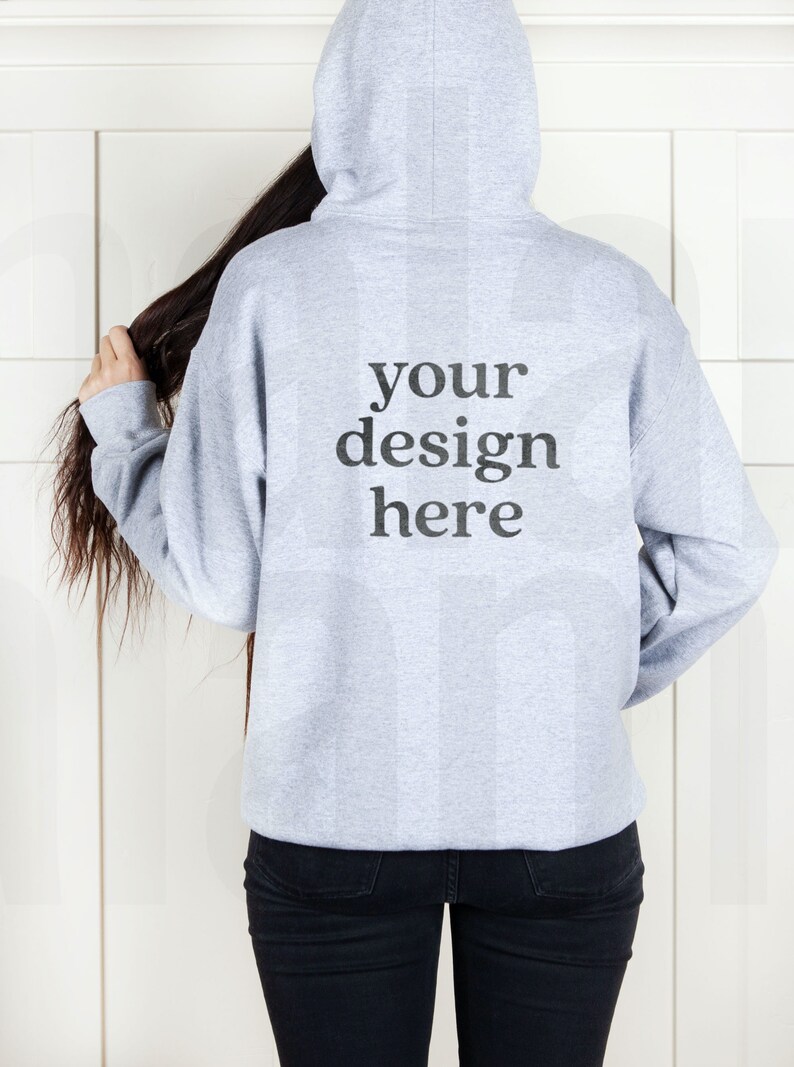May include: A gray hooded sweatshirt with the text "your design here" printed on the back.