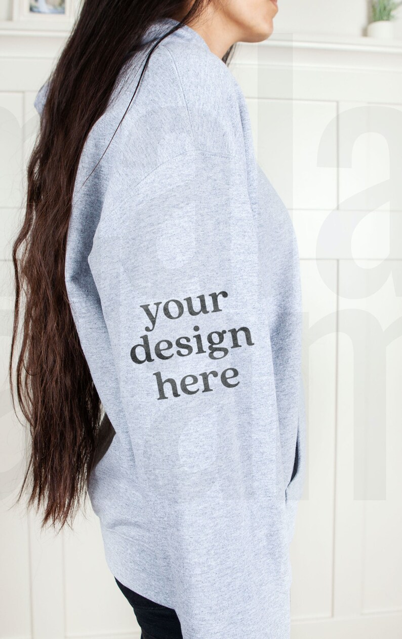 May include: A gray hooded sweatshirt with the text "your design here" printed on the left sleeve.