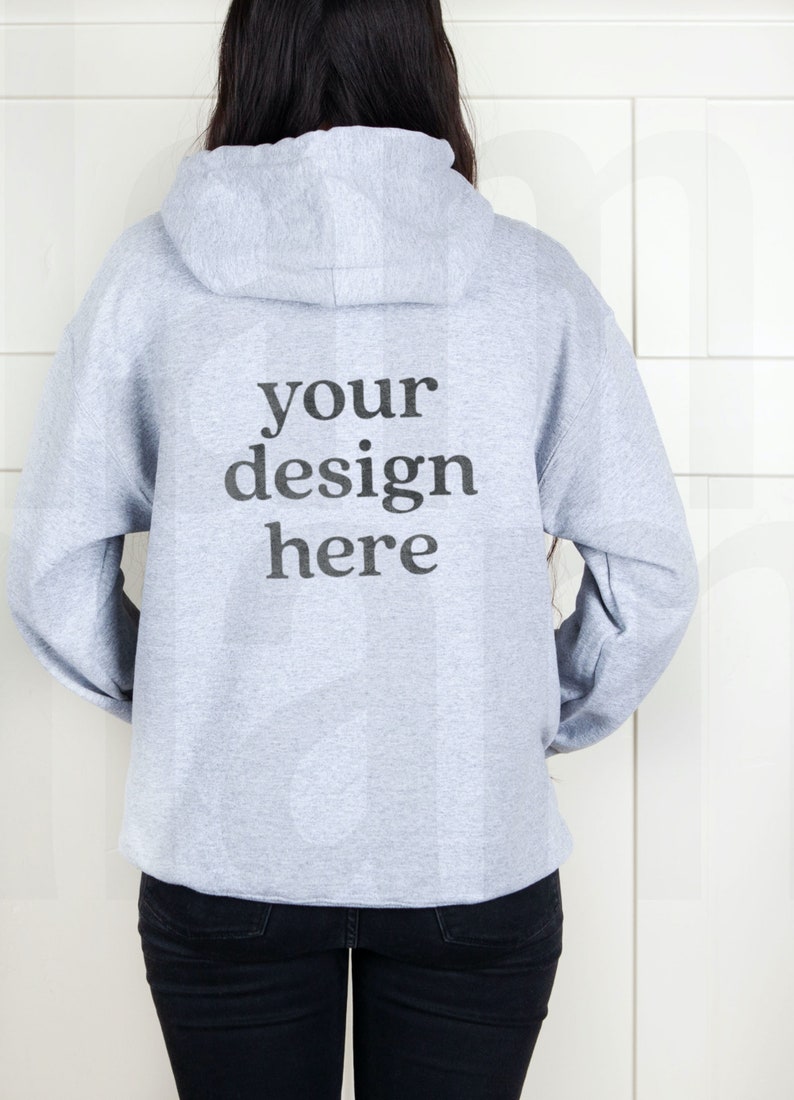 May include: A gray hooded sweatshirt with the text "your design here" printed on the back.