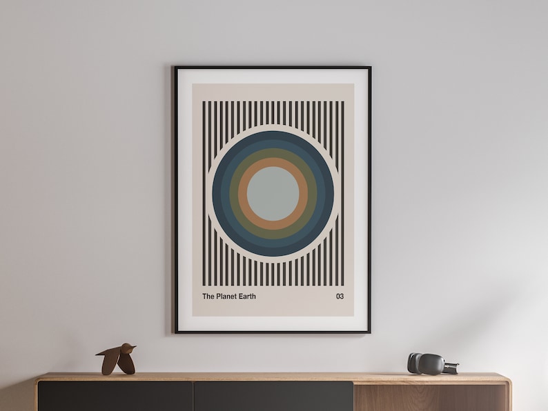 May include: A framed print with a beige background and black vertical stripes. A large blue, green, and brown circle is centered on the print. The text "The Planet Earth" and "03" are at the bottom of the print.
