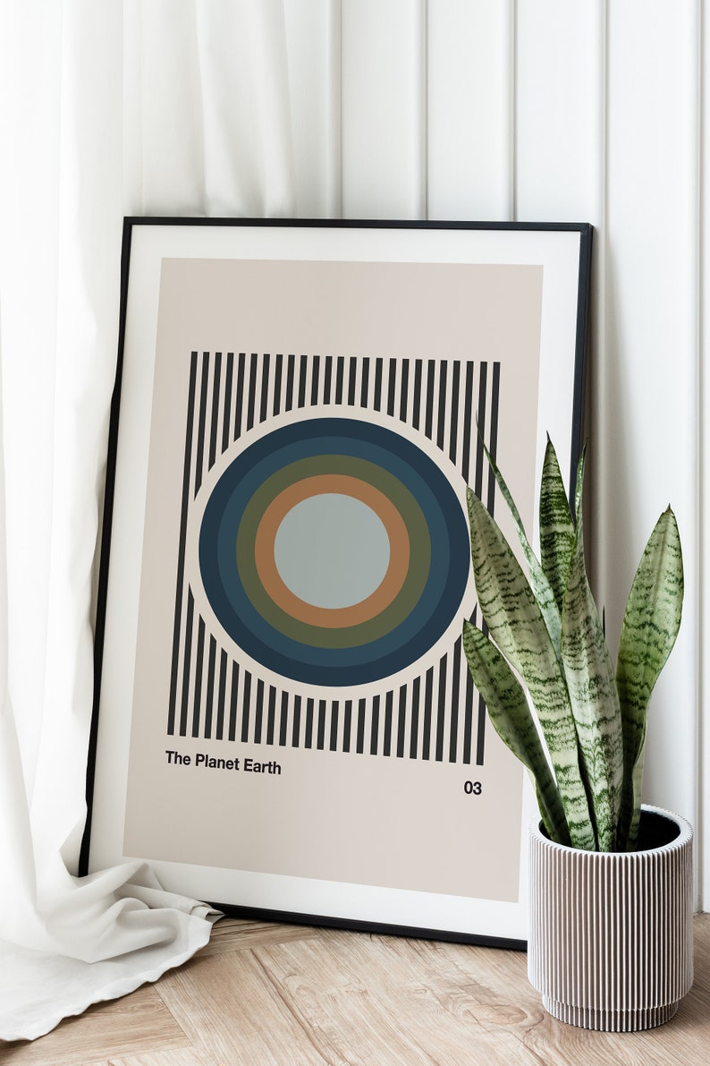 May include: A framed print with a black and white striped background and a concentric circle design in shades of blue, green, and brown. The text "The Planet Earth 03" is at the bottom of the print.
